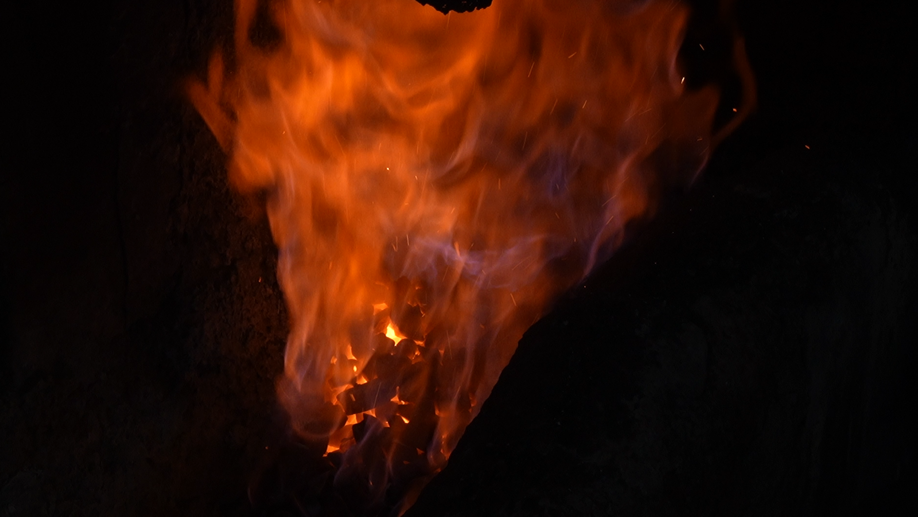 Charcoal burning inside a dark forge