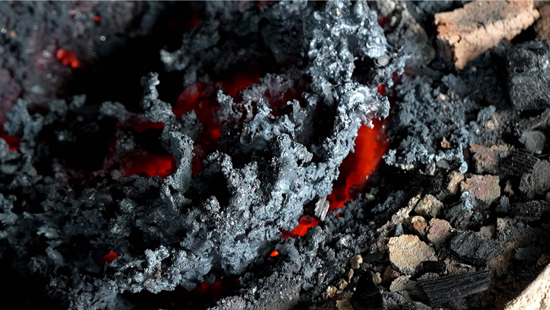 Steel and glowing charcoal inside a forge