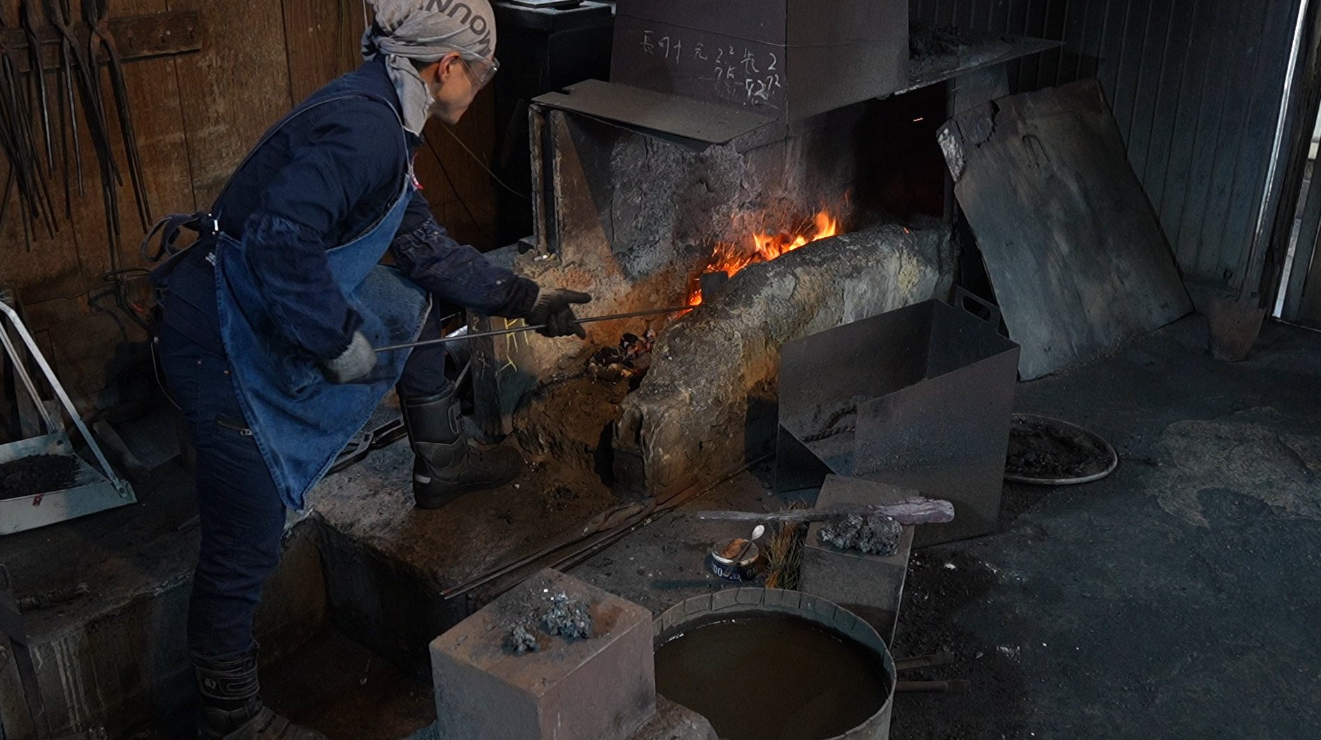 Swordsmith facing the fire at a forge in Bizen Osafune